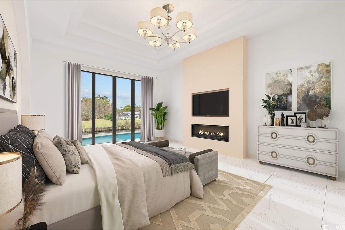 A bedroom in the $3.8 million Grande Dunes area home. It has a fireplace, area for a TV on the wall and a view of the pool and Instracoastal Waterway.