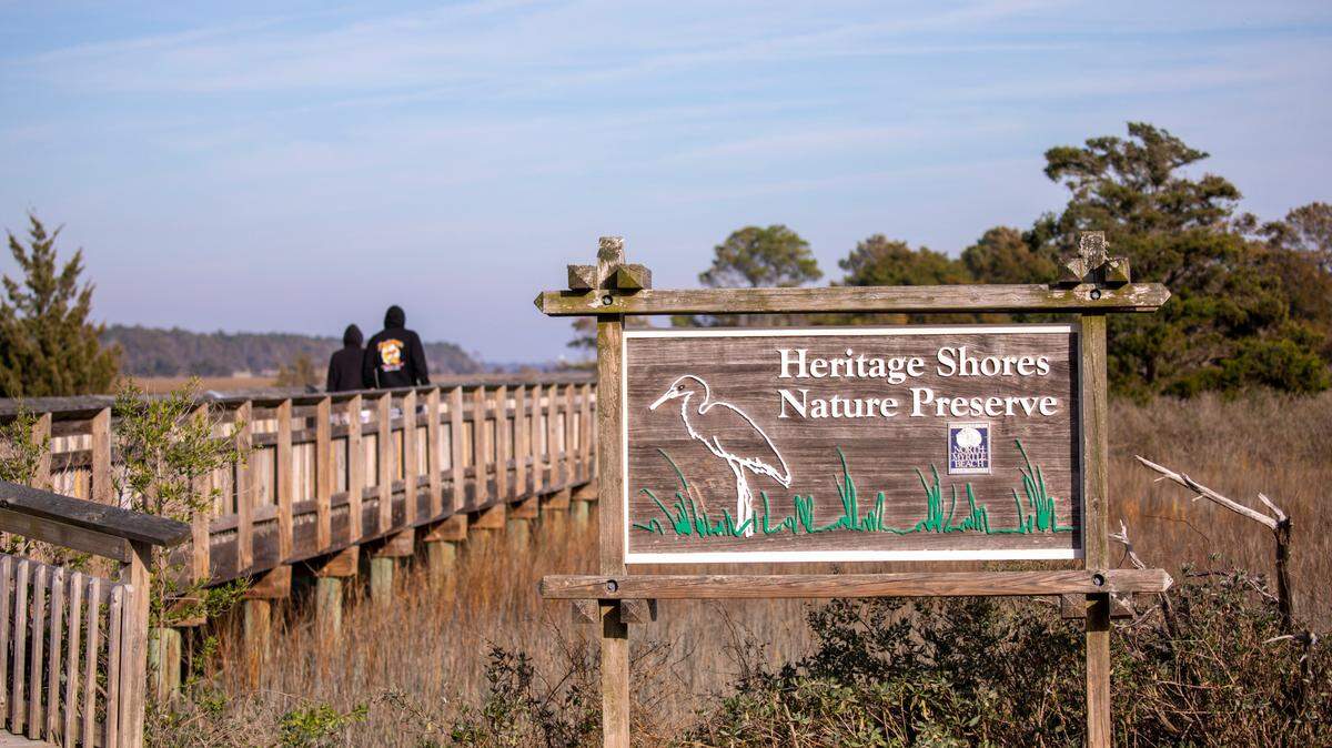 Visitors to the Heritage Shores Nature Preserve walk one of the elevated boardwalks over the marsh at Hog Inlet in North Myrtle Beach. The Myrtle Beach area still has some undisturbed natural places to go for a nature hike. January 11, 2023.