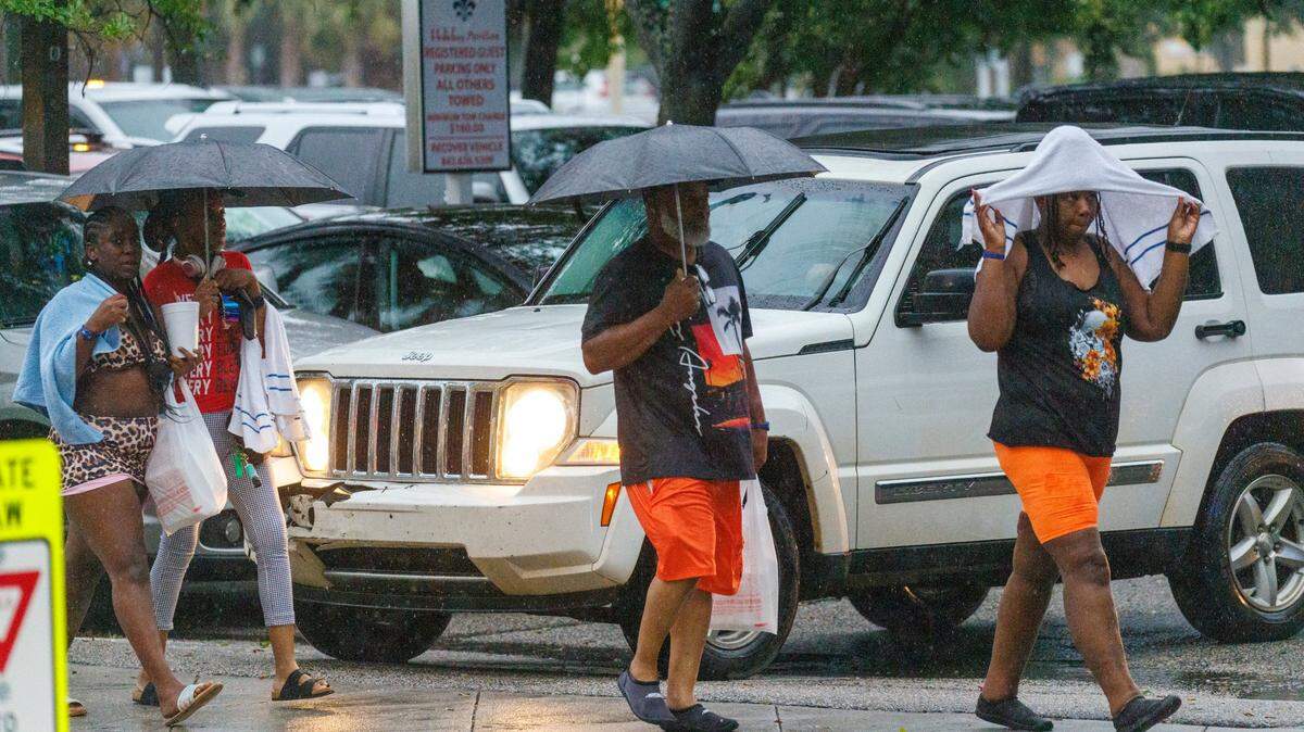 Visitors look for cover from the rain as a storm hits downtown Myrtle Beach on Friday evening. Downtown Myrtle Beach's tourist district was relatively quiet for a Summer evening on Ocean Boulevard and the Boardwalk. Storms put a damper on the evening activities but as the skies cleared, visitors returned to enjoy the attractions. Friday, May 30, 2025.