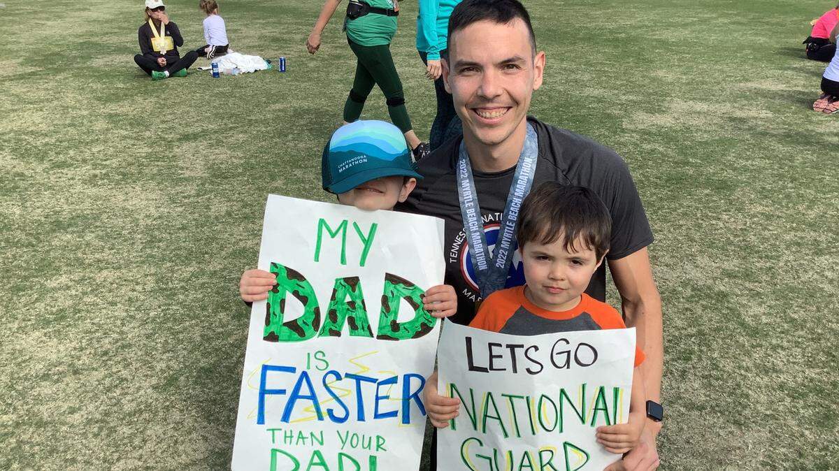 Nathan Wanuch was spurred onto victory in the half marathon race by the encouragement of his sons, Evan (left) and Elliot, who brought signs to encourage all National Guard members entered in the race.