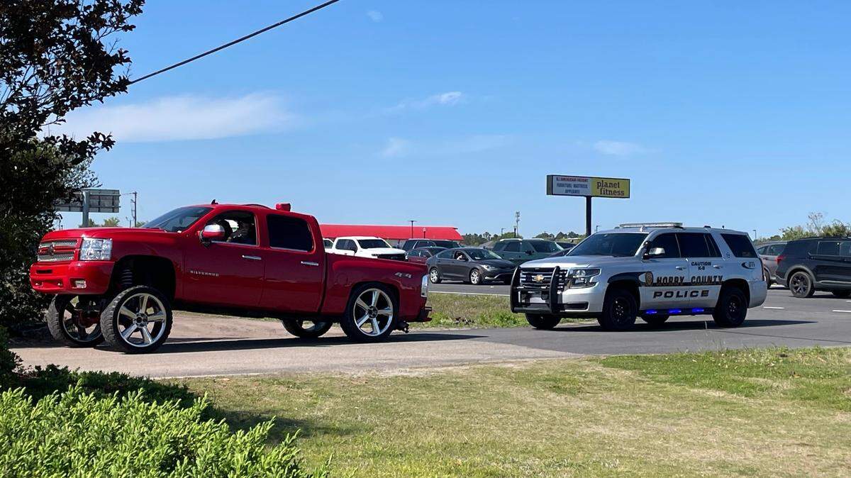 An Horry County Police officer writes a warning ticket for a Carolina squat truck on April 8, 2024. 