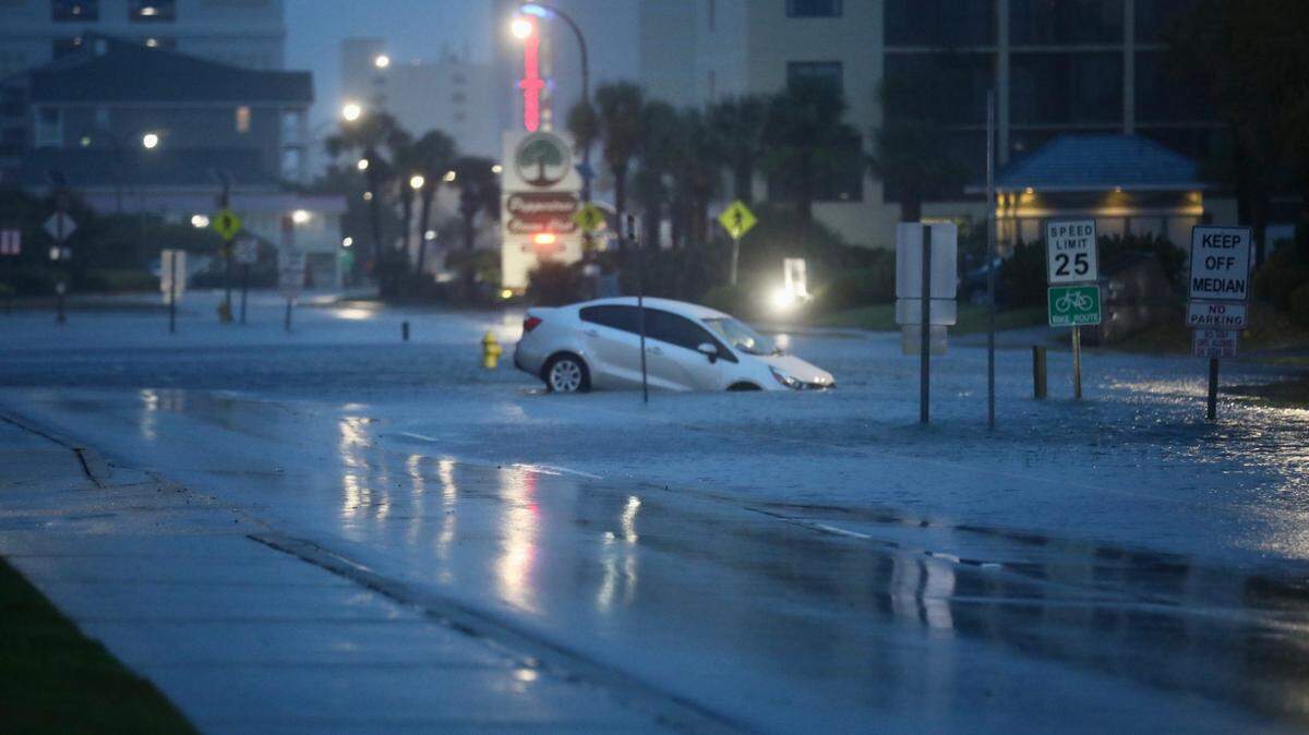 A car sits in a flooded road. Main Street and Ocean Boulevard in North Myrtle Beach saw flooding in the wake of Tropical Storm Idalia. Aug. 30, 2023.