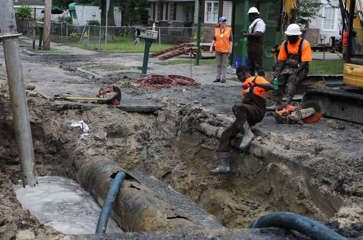 Workers repair an corroded sewage pipe that spilled more than 100,000 gallons of sewer water Monday morning.