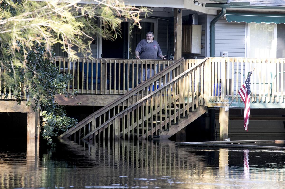 Mike Hanlon looks down from the porch of his  Lee’s Landing home after the flood had crest on Wednesday. To his great relief, he found that the flood’s crest had not reached their home’s main level. The Waccamaw River at Conway crested Wednesday at well over 21 feet flooding many downtown homes. Wednesday, Sept. 26, 2018.