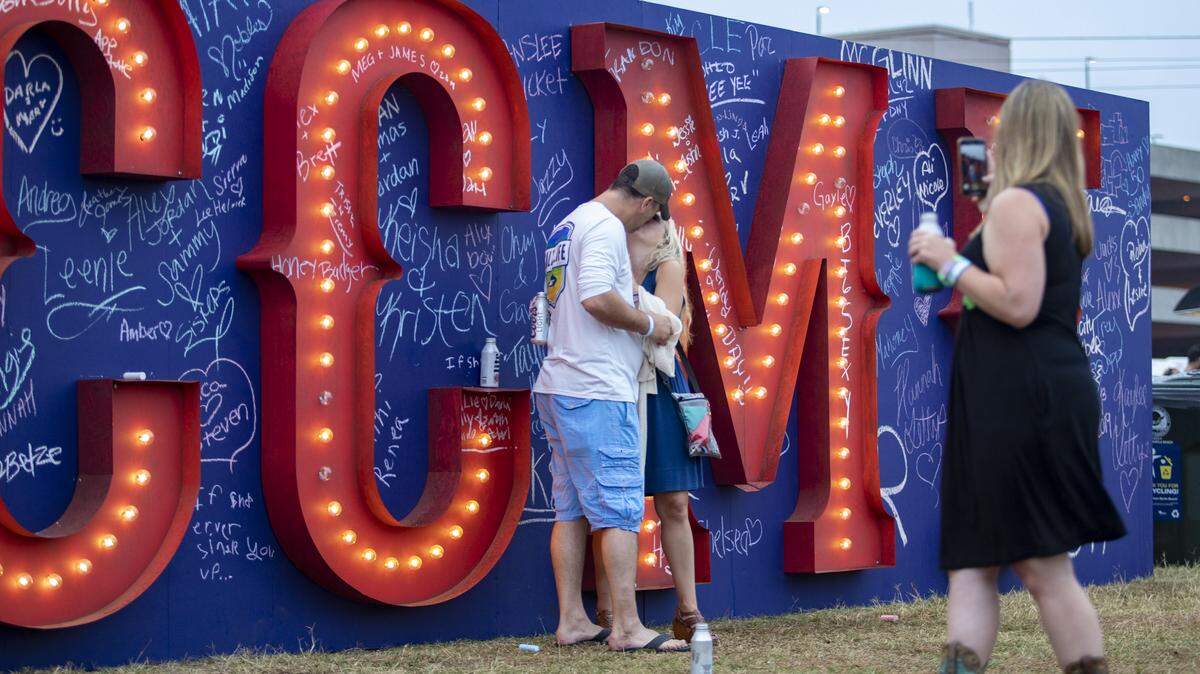 David Allen of Charleston, S.C., kisses his fiancée, Julie Hatfield, also of Charleston, moments after proposing to her in front of the CCMF sign wall at Carolina Country Music Festival in Myrtle Beach Thursday afternoon.