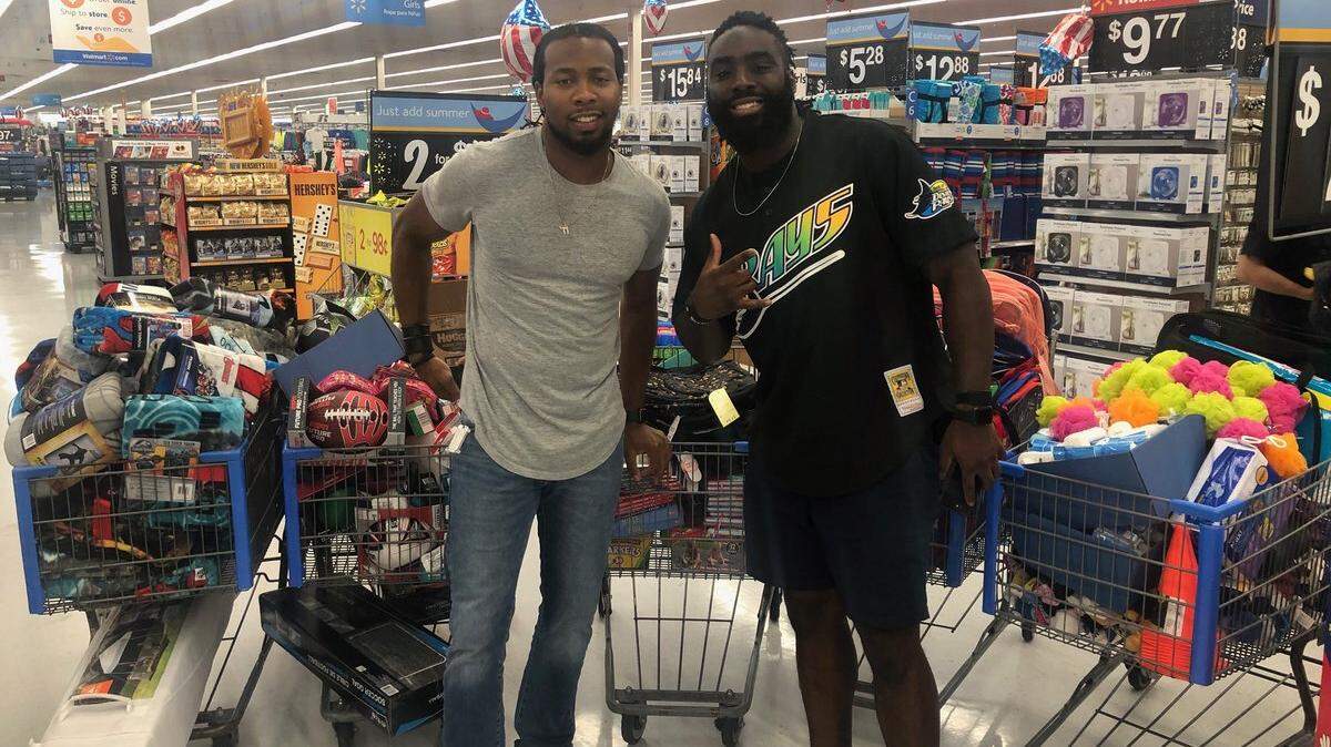 NFL players Josh Norman (left) of the Washington Redskins and Demario Davis of the New Orleans Saints went on a shopping spree Wednesday for immigrant children who had been detained after crossing the U.S. border.