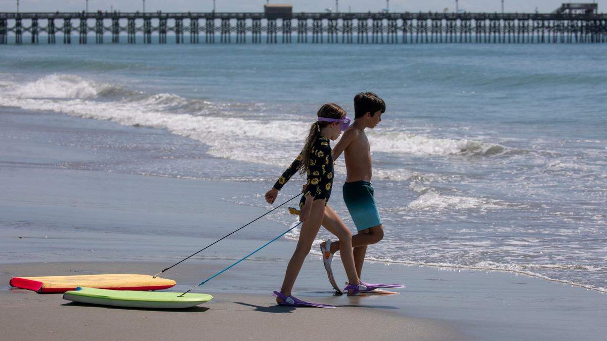 Kids head for the waves in front of the Apache pier at in the Arcadian Shores section of Horry County. The week of Memorial Day marks the unofficial beginning of the tourist season along Grand Strand Beaches. May 31, 2022.
