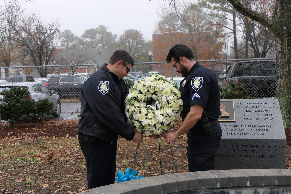 Capt. Eric DiLorenzo, left, and Cpl. Thomas Vest with Myrtle Beach Police Department place a wreath in honor of Officer Joseph John McGarry Jr, who was killed in the line of duty on Dec. 29, 2002.