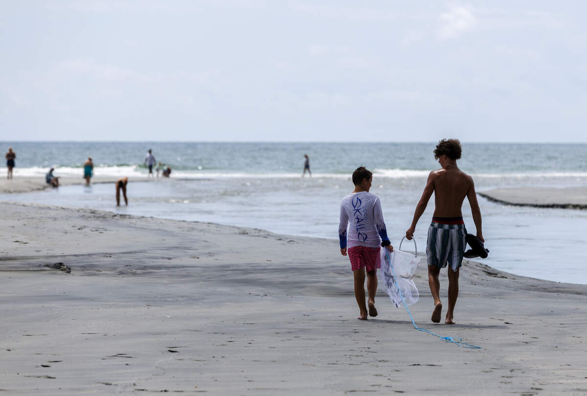 Beach goers wade and play in Singleton Swash, an ocean outfall on the Northern end of Myrtle Beach, SC. The swash is under a long-term swimming advisory from SCDES. July,14 2026