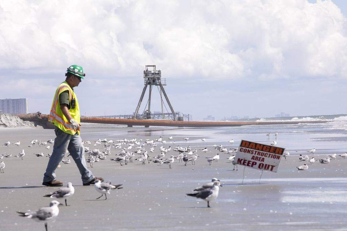 A contractor with the United States Army Corps of Engineers guards the site of beach renourishment in Surfside Beach on Wednesday where a 30-foot-tall “crab” structure provides constant site surveys to assure that 1.4 million cubic yards of sand is distributed properly along Grand Strand beaches. September 5, 2018.