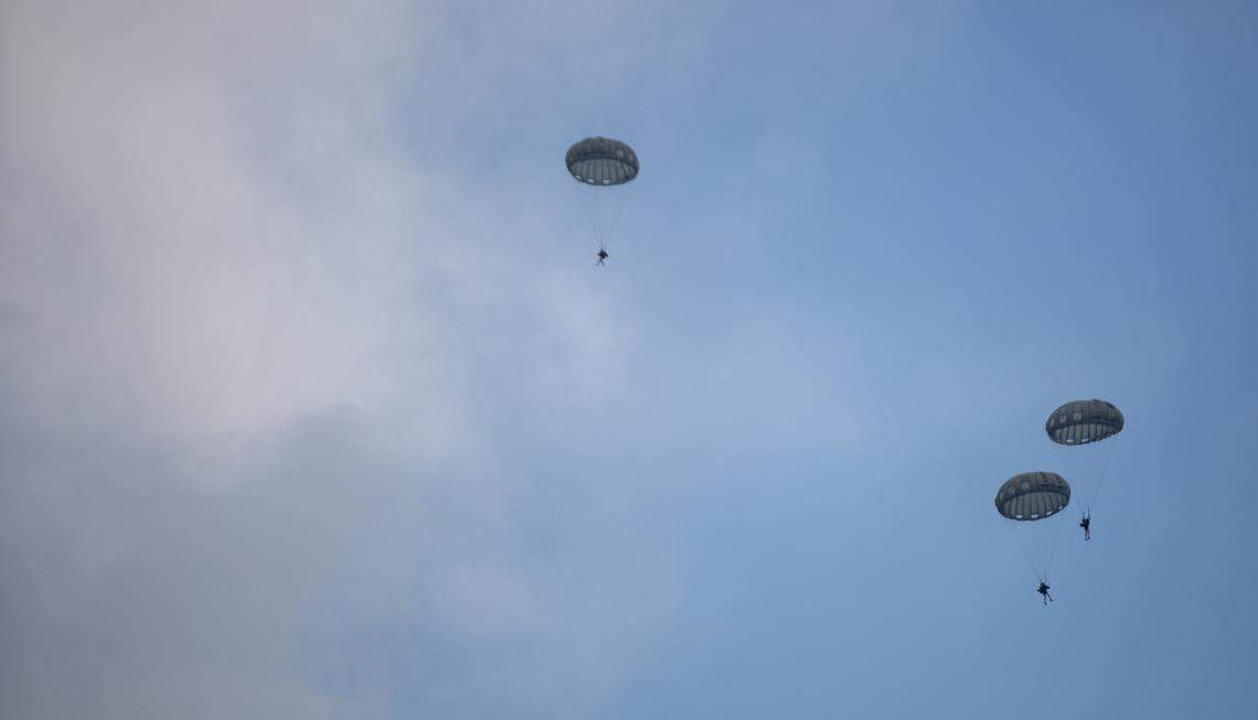 Soldiers from the United States Army Special Operations parachute down into the ocean from Blackhawk helicopters near 27th Avenue South in North Myrtle Beach Thursday afternoon. Tourists and locals gathered on the beach to watch.