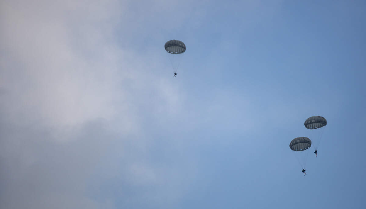 Soldiers from the United States Army Special Operations parachute down into the ocean from Blackhawk helicopters near 27th Avenue South in North Myrtle Beach Thursday afternoon. Tourists and locals gathered on the beach to watch.
