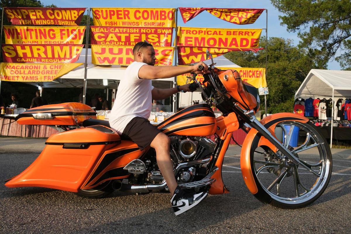 Kenny Lane from New Jersey passes a food vendor in Atlantic Beach, S.C. on his customized bike Friday. The 2024 Black Pearl Cultural Heritage and Bike Festival, also known as Black Bike Week, came roaring into the Northern end of the Grand Strand Friday night. Bikers gathered at the Myrtle Beach Mall to show off their rides, cruised through Atlantic Beach, and partied under beach houses in North Myrtle Beach. S.C. May 24, 2024.