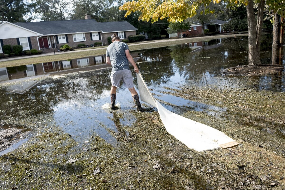 Jess White removes his carpet from his bedroom and moves out into his flooded front yard. This was the first flood where water entered his home. October 1, 2018.