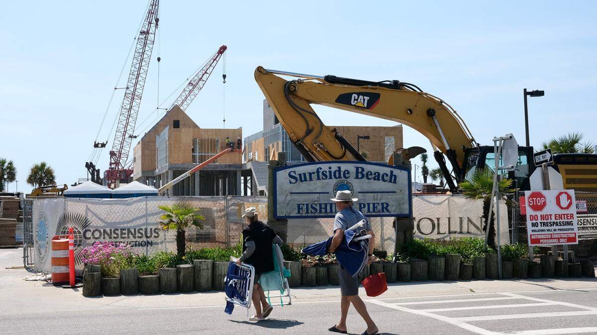 Visitors to Surfside Beach walk to its shores on May 4, 2022. Town officials dropped the speed limit to 10 mph through its entertainment district.