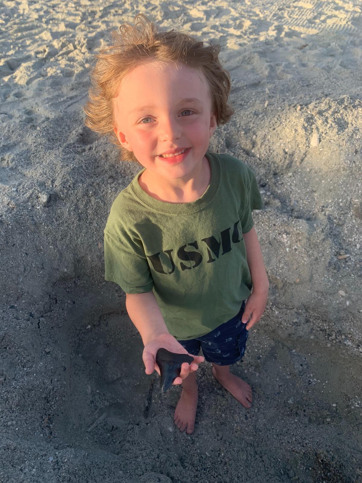 Brantley Griffin, a 5-year-old from Asheboro, N.C., holds a megalodon shark tooth he found Thursday on the beach in the Cherry Grove section of North Myrtle Beach.