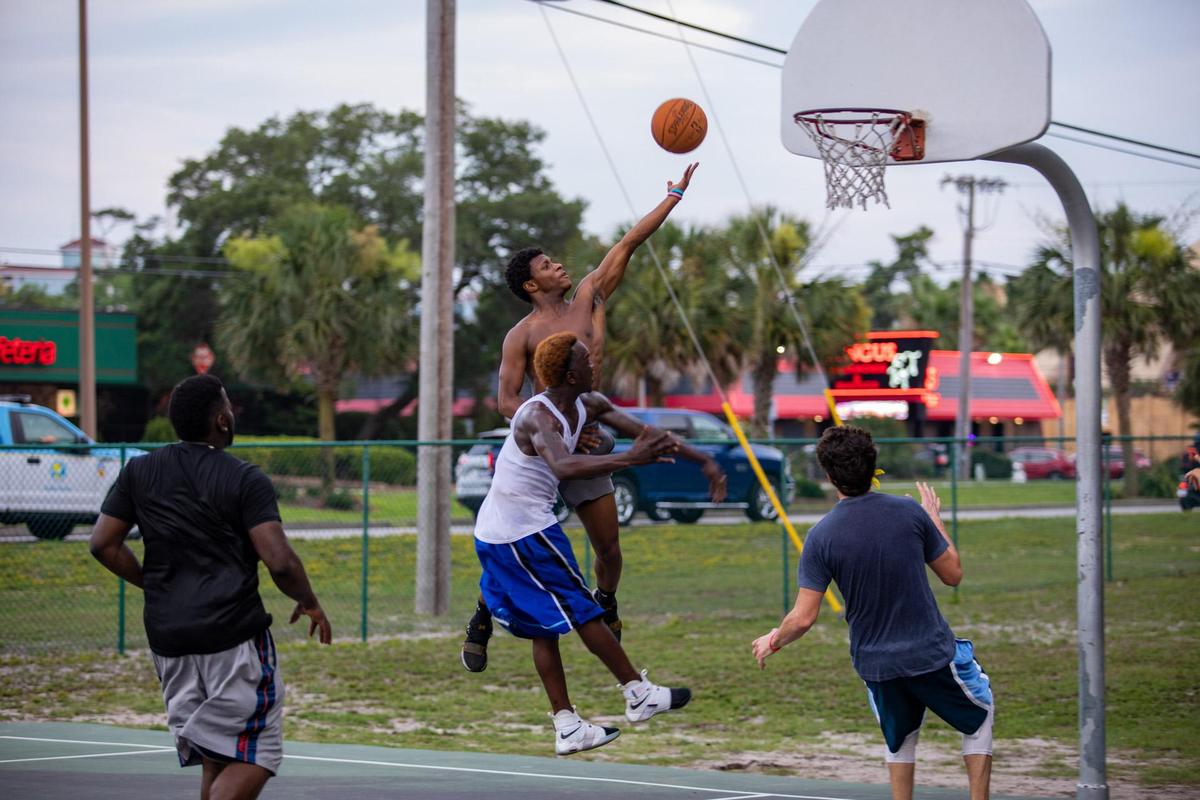 Myrtle Beach residents participate in a game of pick-up basketball on the basketball court at Midway Park in Myrtle Beach Sunday afternoon.