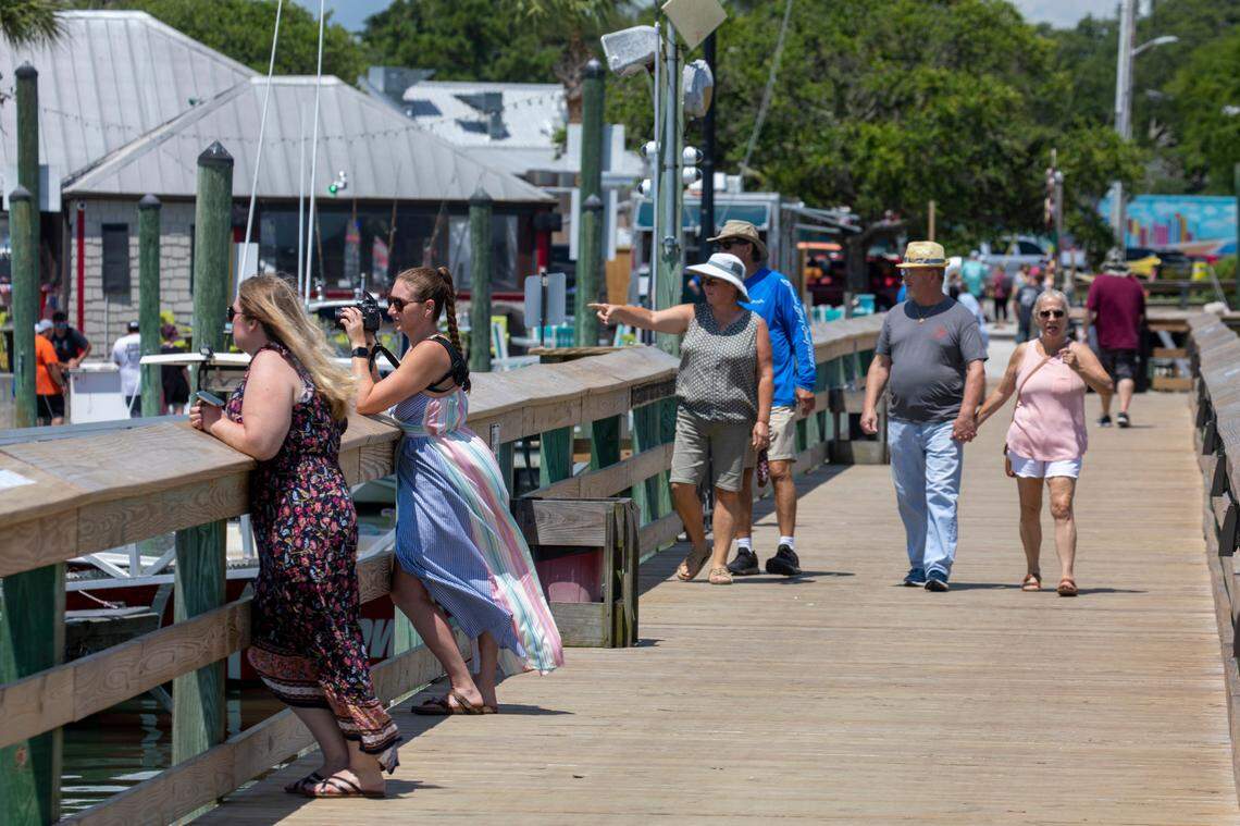 People walk Veterans Pier and Marshwalk in Murrells Inlet. In the summer heat of July, Myrtle Beach area residents and tourist look to the water for relief. With waterparks, jet ski rentals, parasails, banana boat rides, paddle boards and kayaks, there are plenty of options to beat the heat. July 5, 2022.