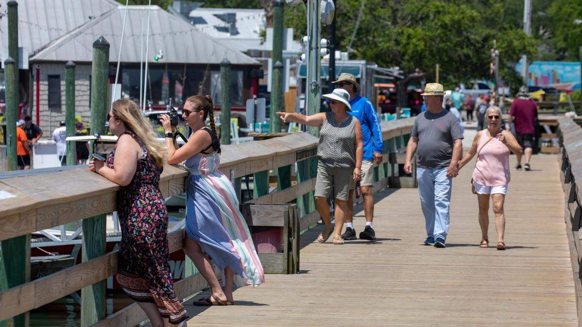 People walk Veterans Pier and Marshwalk in Murrells Inlet in July 2022. The small community has been named one of the best small towns in the South.
