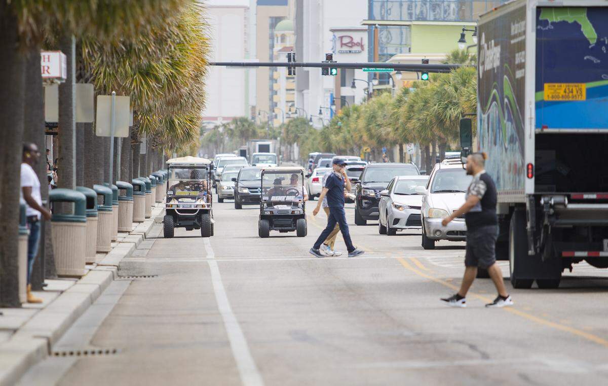 Golf carts drive down Ocean Boulevard in Myrtle Beach Tuesday afternoon.