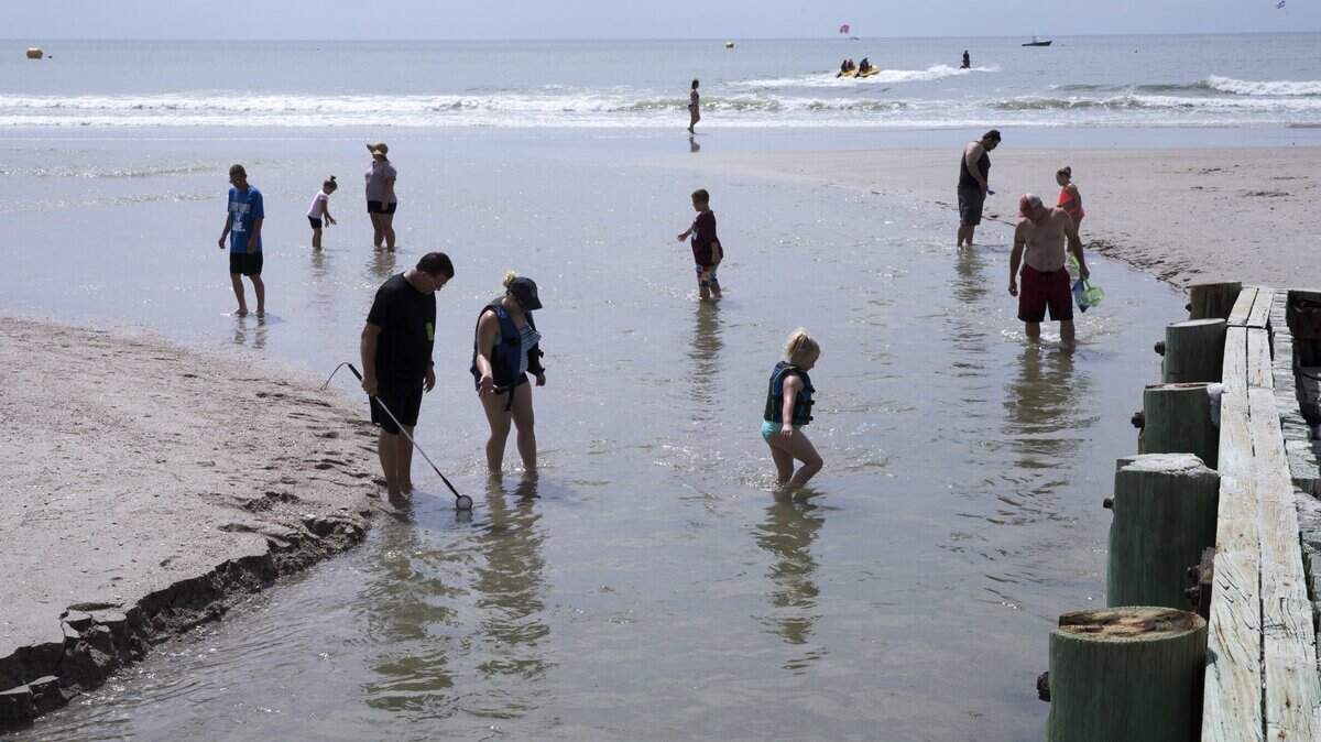 Beachgoers wade across Wither’s Swash close to a nearby water sports activity vendor near 4th Avenue South in Myrtle Beach. The Department of Health and Environmental Control has  warned against swimming local swashes due to higher levels of bacteria in the water. June 28, 2018.