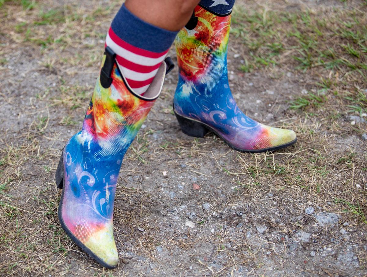 Linda Deem shows off her tie-dyed rainboots Friday afternoon on day 2 of Carolina Country Music Fest in Myrtle Beach.