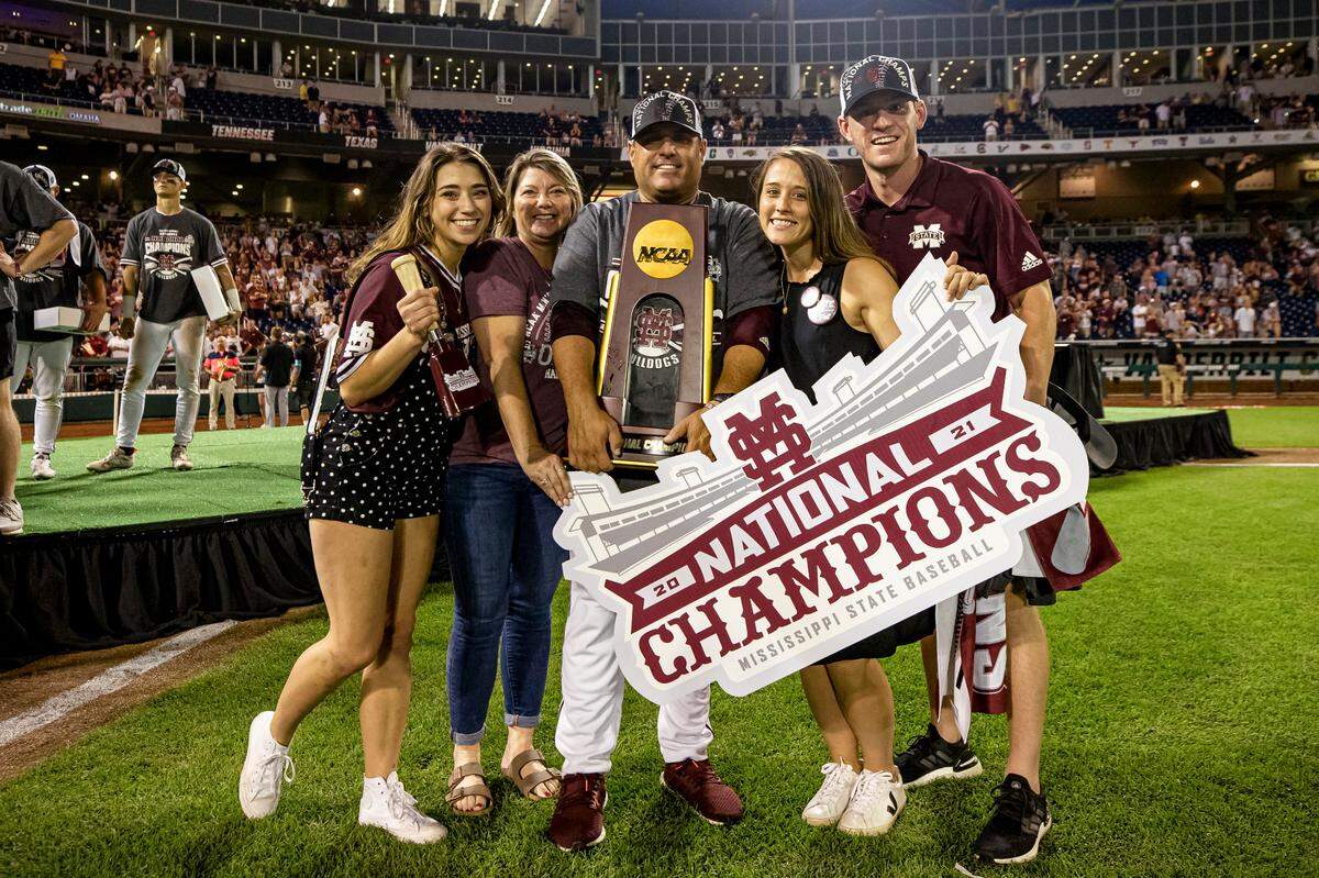 Mississippi State head coach Chris Lemonis holds the NCAA national championship trophy and poses with his family after the 2021 College World Series national championship game between the Bulldogs and Vanderbilt at TD Ameritrade Park in Omaha, Nebraska.