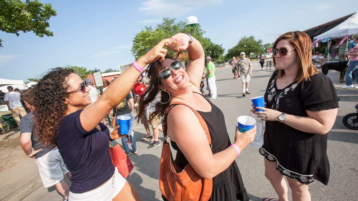 Natasha Oquendo (left) and Sara Bird dance in the street at the 30th Annual Rivertown Music & Craft Beer Festival May 7, 2016 in historic downtown Conway, SC. The event features music, craft beer tasting, historic cars, and street vendors.