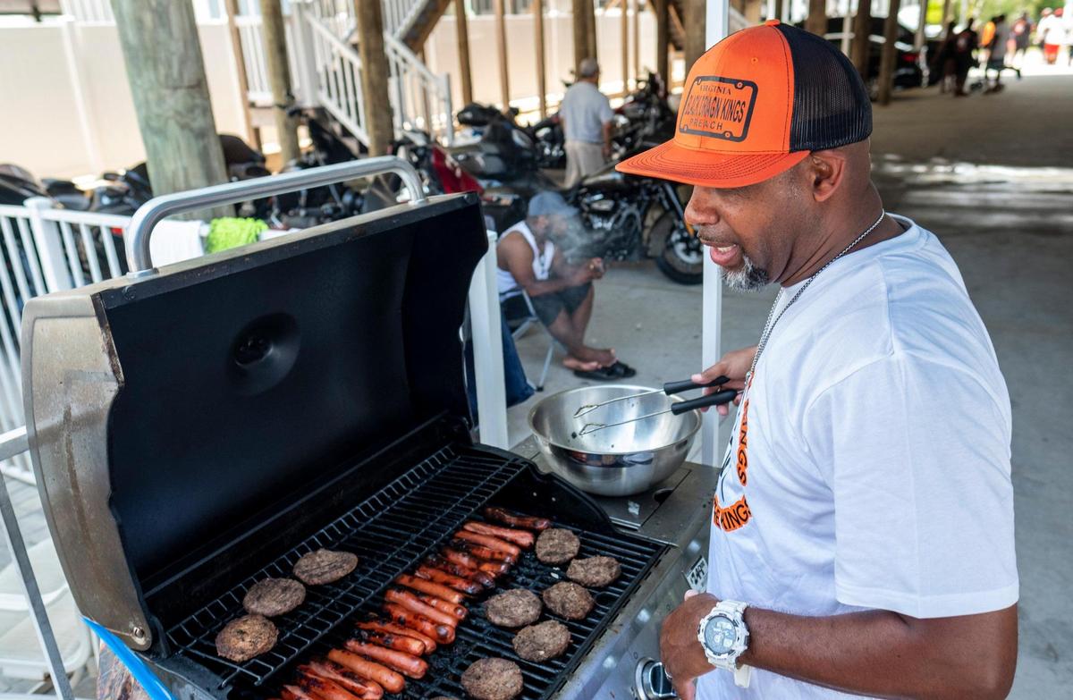 Demond Jamison of Richmond, Va cooks hotdogs and hamburgers for members of the Black Dragon Kings Motorcycle Club under a beach house in North Myrtle Beach on Thursday. Small groups of bikers have arrived on the North end of the Grand Strand for Memorial Day weekend despite Atlantic Beach canceling it’s annual motorcycle festival for the second year due to COVID-19. May 27, 2021.