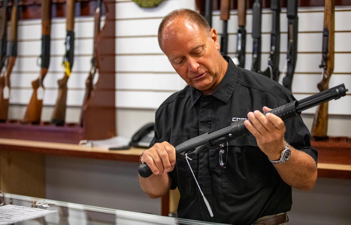 Cormac Director of Law Enforcement Sales Douglas Kahn Rifles holds a shotgun behind the counter of his store along 38th Ave. N. in Myrtle Beach. In addition to gun sales and apparel, the new tactical shop supplies law enforcement agencies with tactical gear.