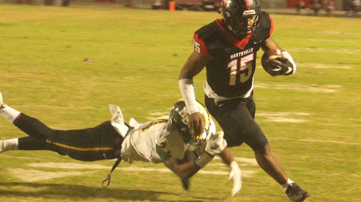 Hartsville quarterback Tiyon Evans (15) slips out of the tackle of Myrtle Beach’s Shedrick Pointer (24) on his way to his first touchdown of the night in Hartsville’s 70-34 victory on Thursday.