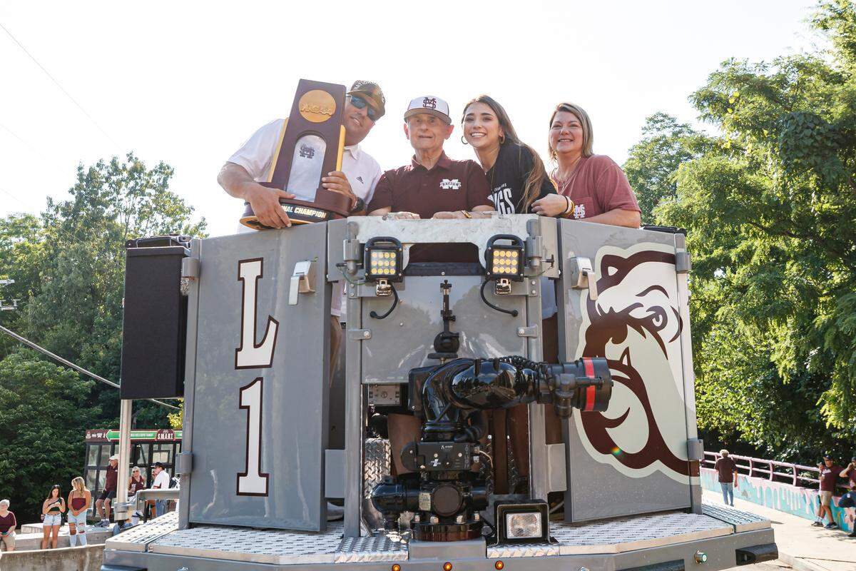 Mississippi State head coach Chris Lemonis (left), his father Thomas, a daughter and wife Jill during a victory parade in Starkville, Mississippi, celebrating the Bulldogs’ College World Series national championship win.