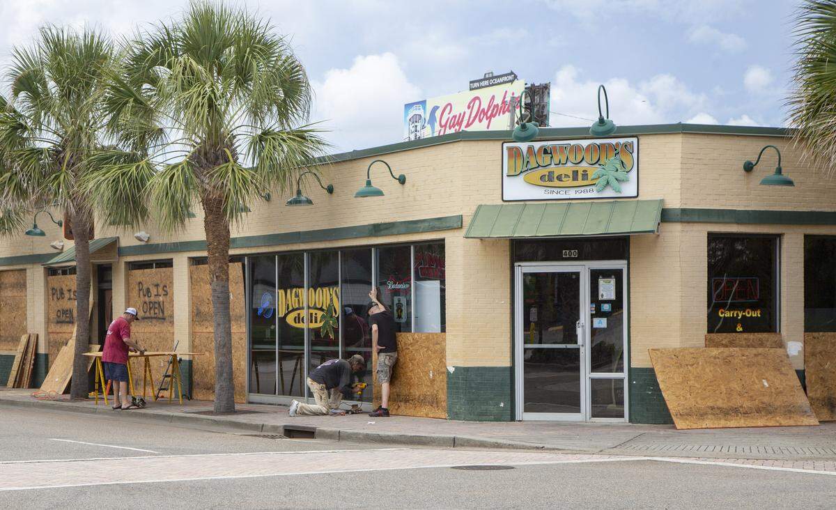 Crews work to board up the exterior of Dagwood’s Deli and Bumstead’s Pub on Tuesday before the arrival of Hurricane Florence in Myrtle Beach.