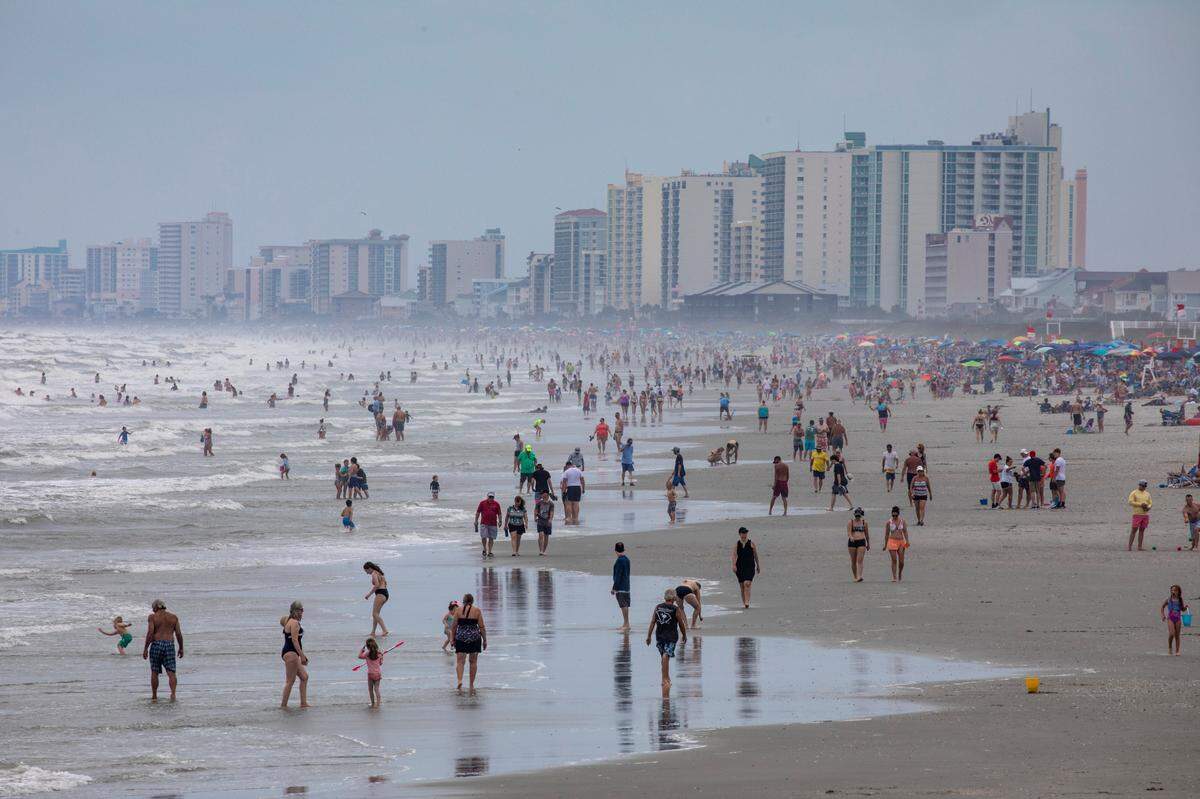 Beachgoers pack the beach in the Cherry Grove section o North Myrtle Beach. On boats, beaches and the boulevards, tourists and residents enjoy the first days of the summer season on the Grand Strand during Memorial Day weekend 2021. May 29, 2021.