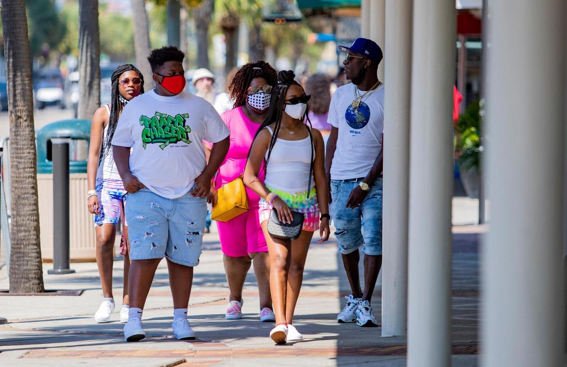 Masked pedestrians walk along Ocean Boulevard Tuesday afternoon in Myrtle Beach. Coronavirus cases grew by 150 and two virus-related deaths were reported in Horry County on Tuesday, according to state health officials.
