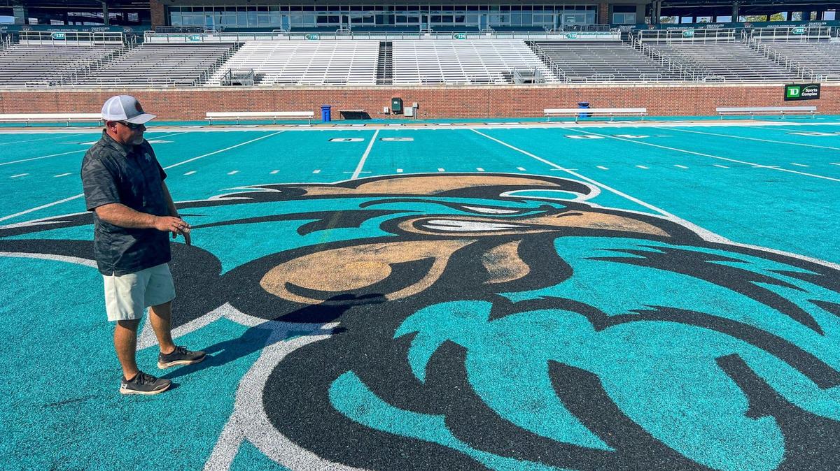 Scott Grinter, Coastal Carolina’s assistant superintendent explains how the artificial turf can be patched together to repair damaged sections of the field. Coastal Carolina University ground keepers perform maintenance on CCU’s fabled teal turf assuring that the synthetic field is safe, playable and looks good for home games. Sept. 30, 2024.