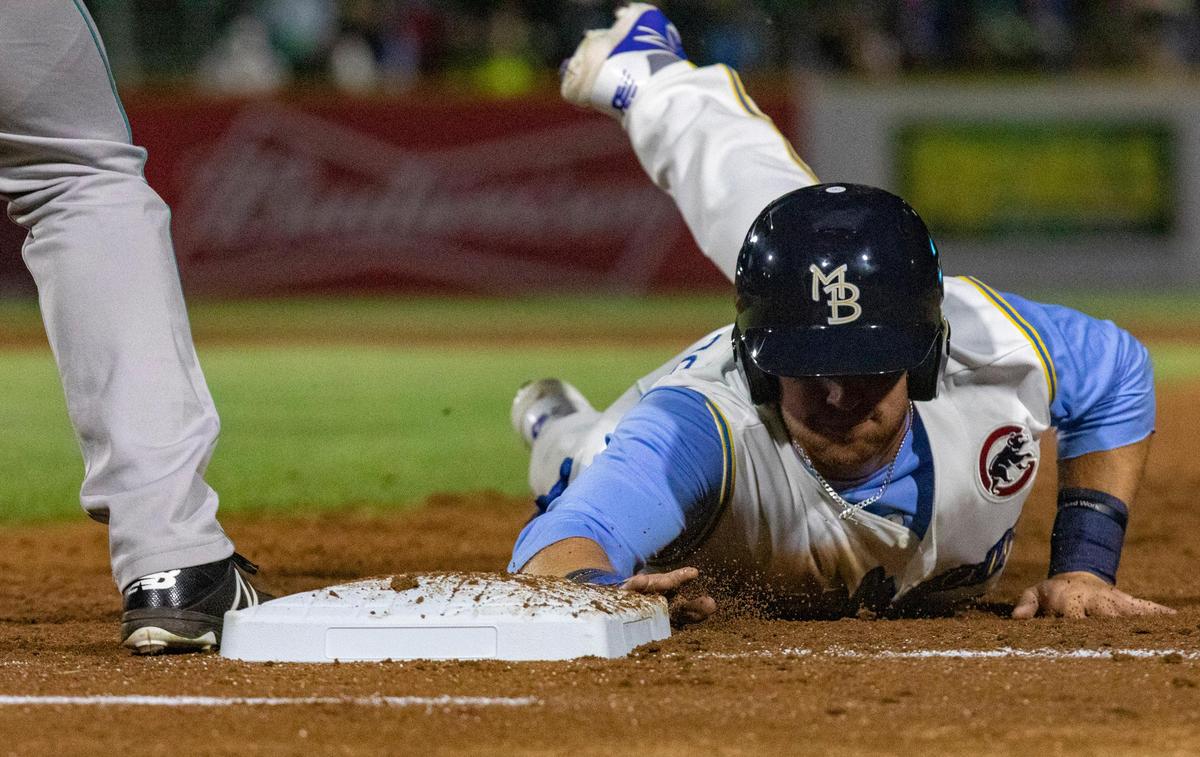 Myrtle Beach Pelicans first baseman Luke Reynolds slides into first to avoid a tag in the Pelicans’ 2019 opening day game against the Lynchburg Hillcats in Myrtle Beach.