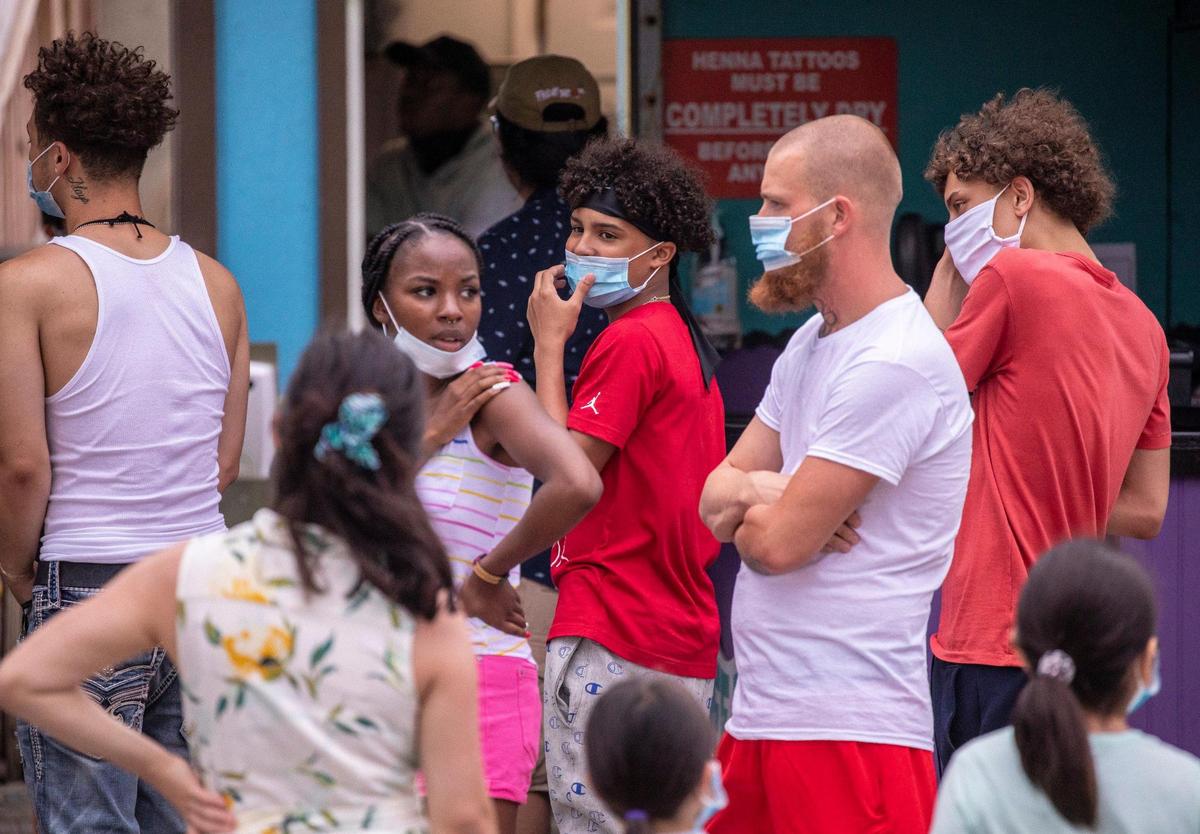 People wear masks while standing in line on Ocean Boulevard in Myrtle Beach. After a busy holiday weekend in which the City of Myrtle Beach enacted mask regulations to combat the coronavirus pandemic, Ocean Boulevard and area attractions were relatively quiet on Tuesday, July 7, 2020.