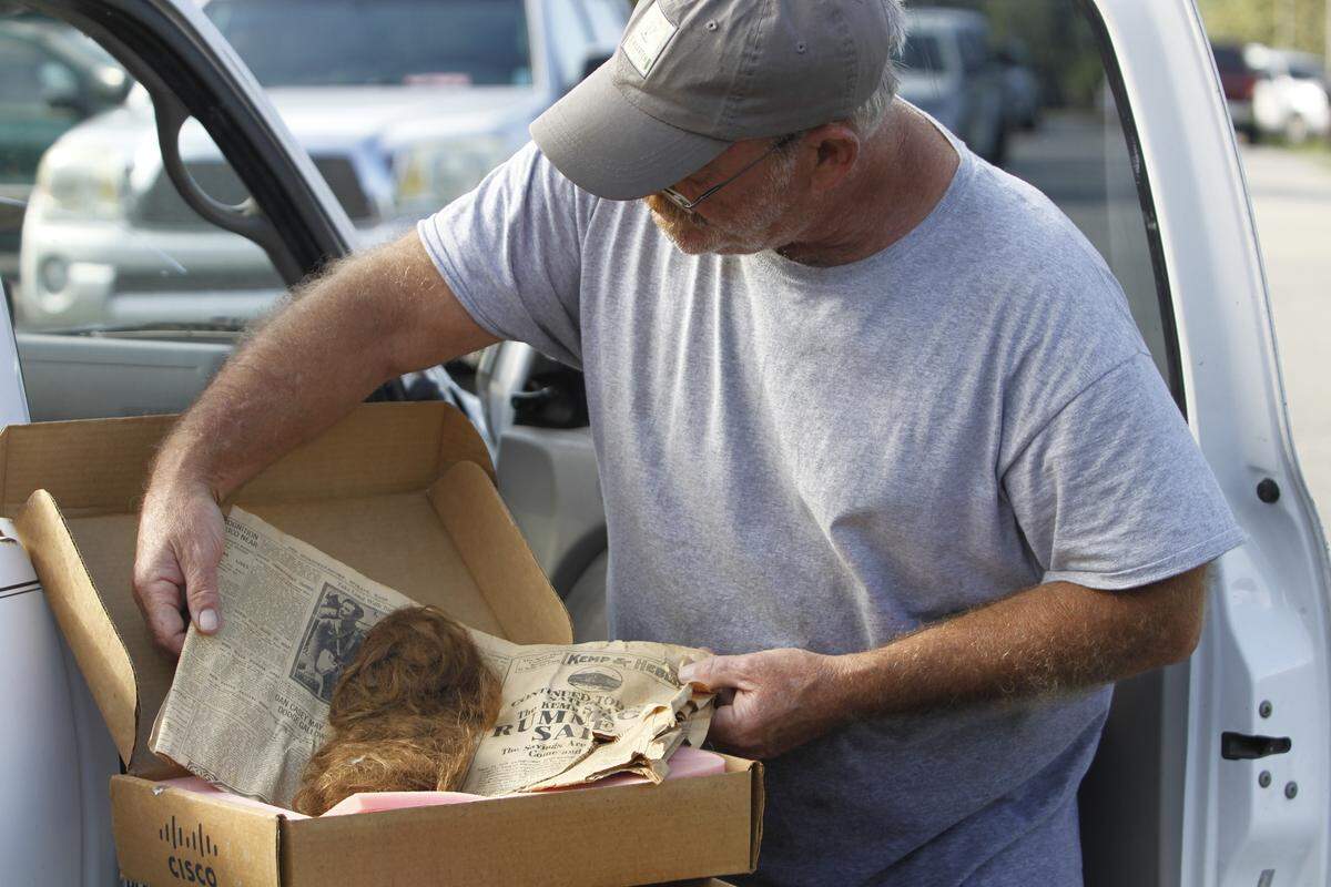 Phil Sherengos holds his grandmother’s hair from her first haircut on Aug. 24, 1923. Sherengos saved the sentimental item as waters flood the Rosewood Estates neighborhood he lives in. Sept. 24, 2018
