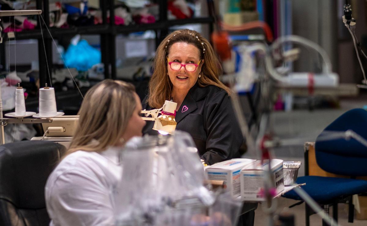 Tara Grinna jokes with volunteers as they sew new elastic into stockpiled medical masks at the Tara Grinna Swimwear factory in Conway. The factory converted their operations from making custom swimsuits to sewing elastic into N95 masks in response to the coronavirus. Tidelands Health has delivered 35,000 of the masks that were held in storage with degraded elastic bands. The swimwear manufacturer’s sewers, many of whom are at high risk for the virus, all volunteered to come back to work to complete the project along with help from volunteers within the community. March 30, 2020.
