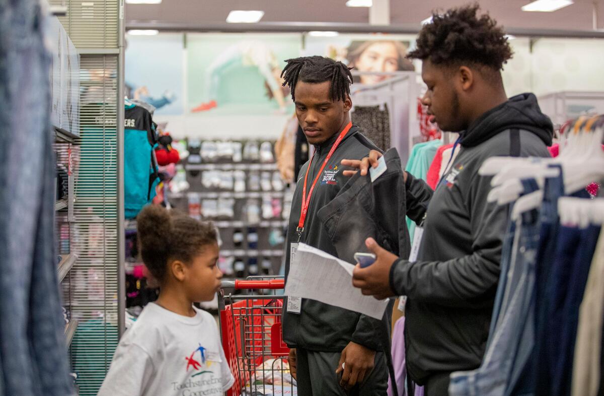 Myrtle Beach linebacker Shedrick Pointer (left) and Ridgeview offensive lineman Chandler Muller shops with Myrtle Beach Elementary student Ariyona Guy at Target in Myrtle Beach Thursday afternoon as football players from the North and South squads playing in the 2019 Touchstone Energy Bowl take Myrtle Beach Elementary students shopping. The players were given a $150 Target gift to help the students shop for items on their wish lists.
