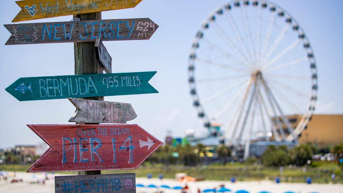 Signs point to various locations along Pier 14 with the Myrtle Beach SkyWheel looming in the background. FILE