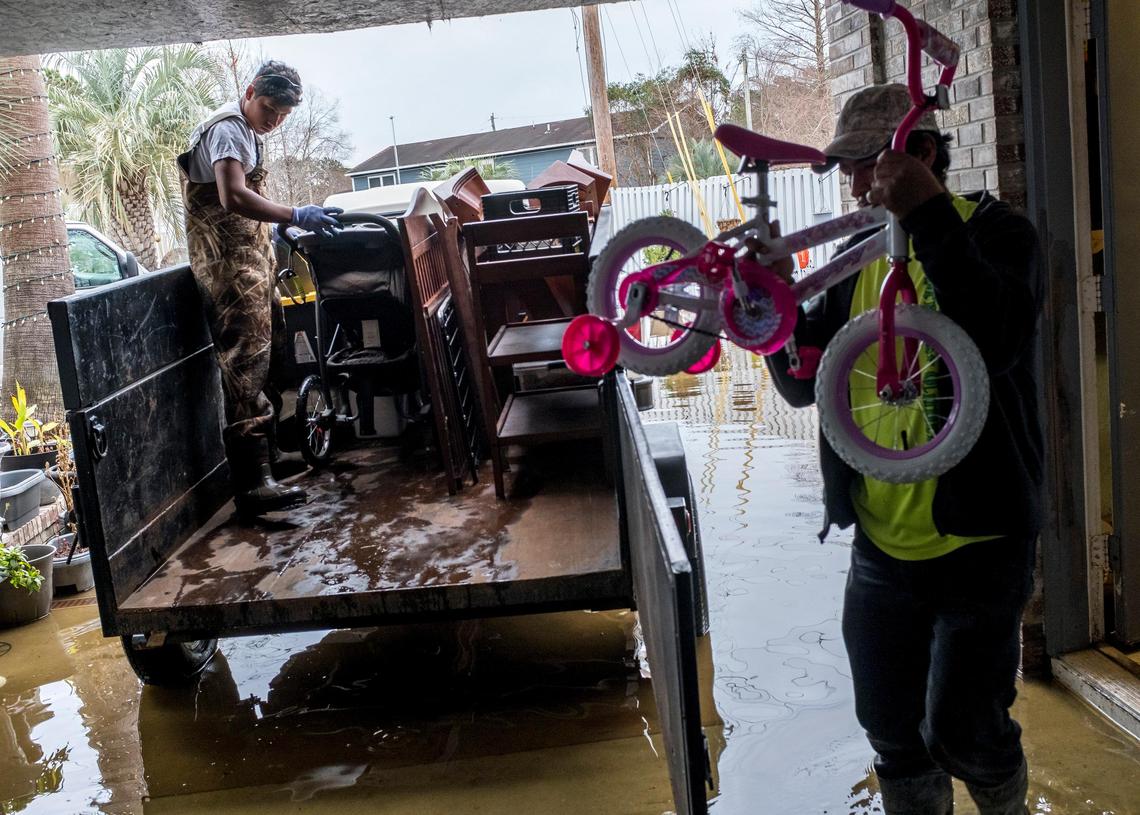 A work party helps Oscar Leroy move things out of the lower level of his Rosewood community home on Tuesday. Leroy says he has remodeled his home four times in recent years due to flooding. February 18, 2020.