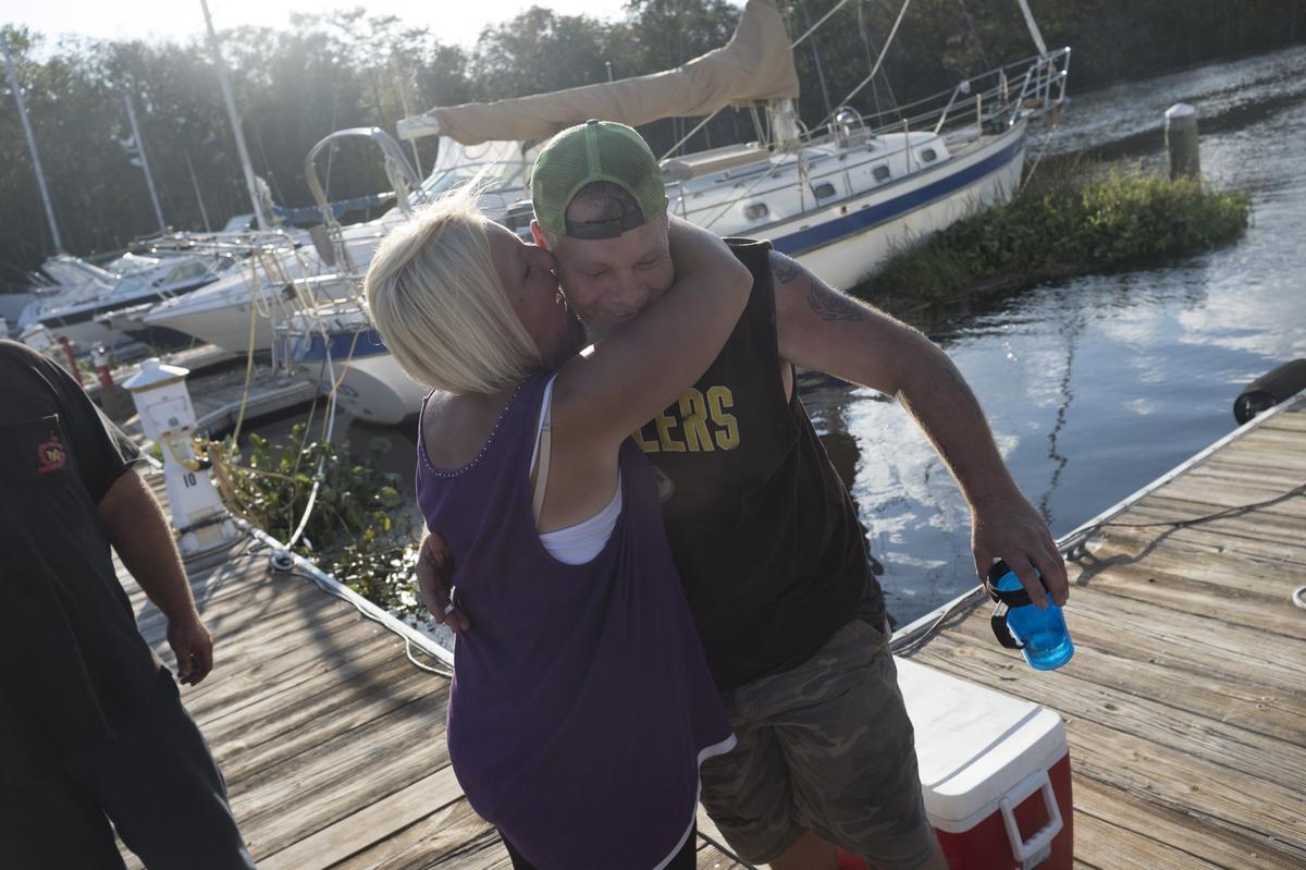 Gina Gerber gives Courtenay Starr a hug after delivering him supplies at Bucksport Marina. Starr, who is living on a boat at the marina with Patti Lous(not pictured) has been cut off from supplies by rising flood waters. The Waccamaw River at Conway crested Wednesday at well over 21 feet flooding many downtown homes. Wednesday, Sept. 26, 2018.