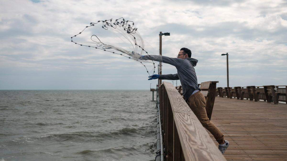Adrian Martin of New York casts a net off the Springmaid Pier in Myrtle Beach. The area’s only concrete based pier was rebuilt after being damaged by Hurricane Matthew. Myrtle Beach area piers take a frequent battering from systems but a strong pier culture prevails drawing fisherman and tourist back year after year. October 10, 2022.