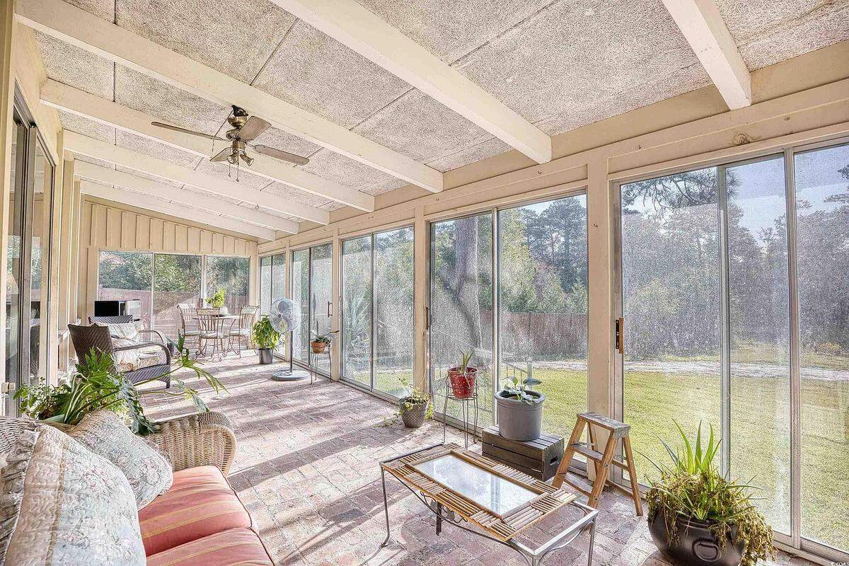 The back porch has a wall covered in glass sliding doors, letting in ample light while offering some insulation from the elements.