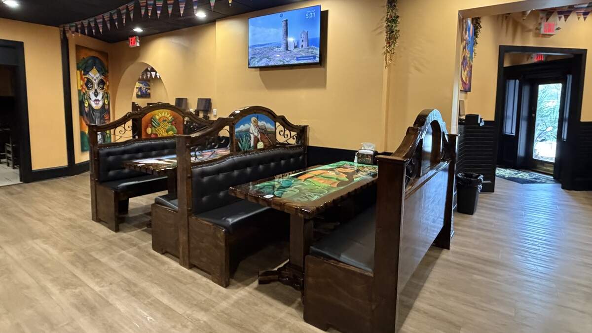 The interior of El Patron Mexican Bar & Grill features paintings imported from Mexico on the walls, booths and tables.