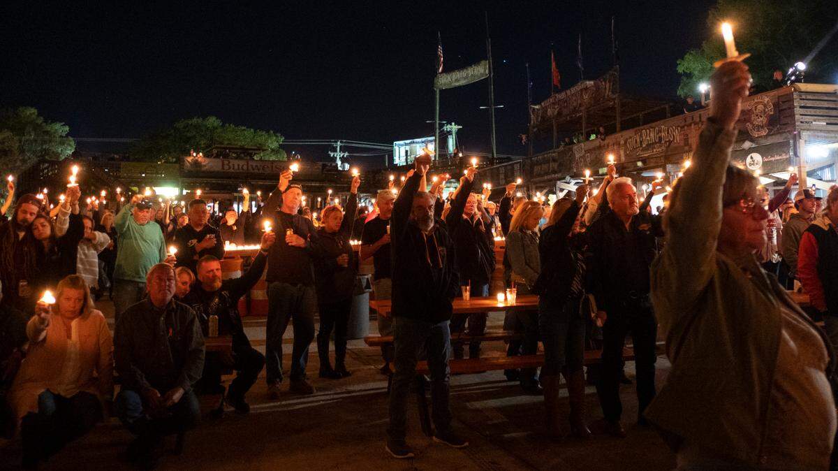 Hundreds held candles outside of Suck Bang Blow to honor Stephen Pease, teh bar’s co-owner who died in a motorcycle crash.
