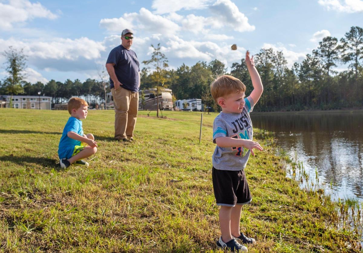 Scott IIams of Charleston, SC with sons Wesson and Waylon, skip rocks in a pond at Carolina Pines RV resort.