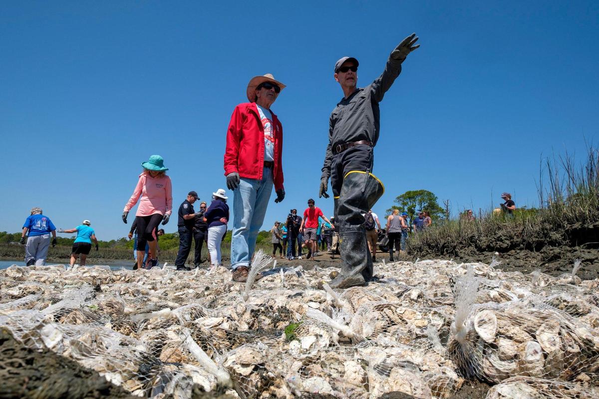 Keith Walters, a Marine Science professor at Coastal Carolina University explains the oyster reef restoration project in Hog Inlet to volunteers. April 28, 2022.